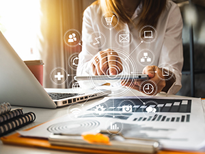 Woman at a desk with marketing tactics icons